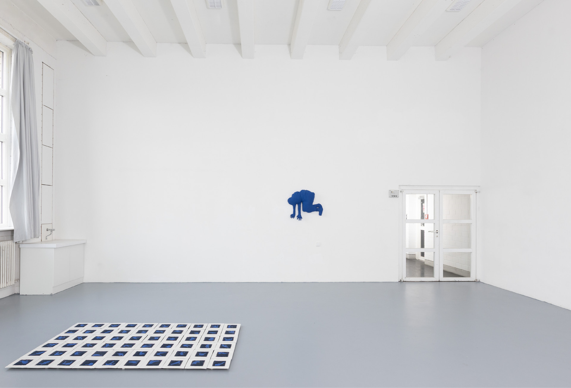 Room view with the blue textile body on the wall and the tiles on the floor
