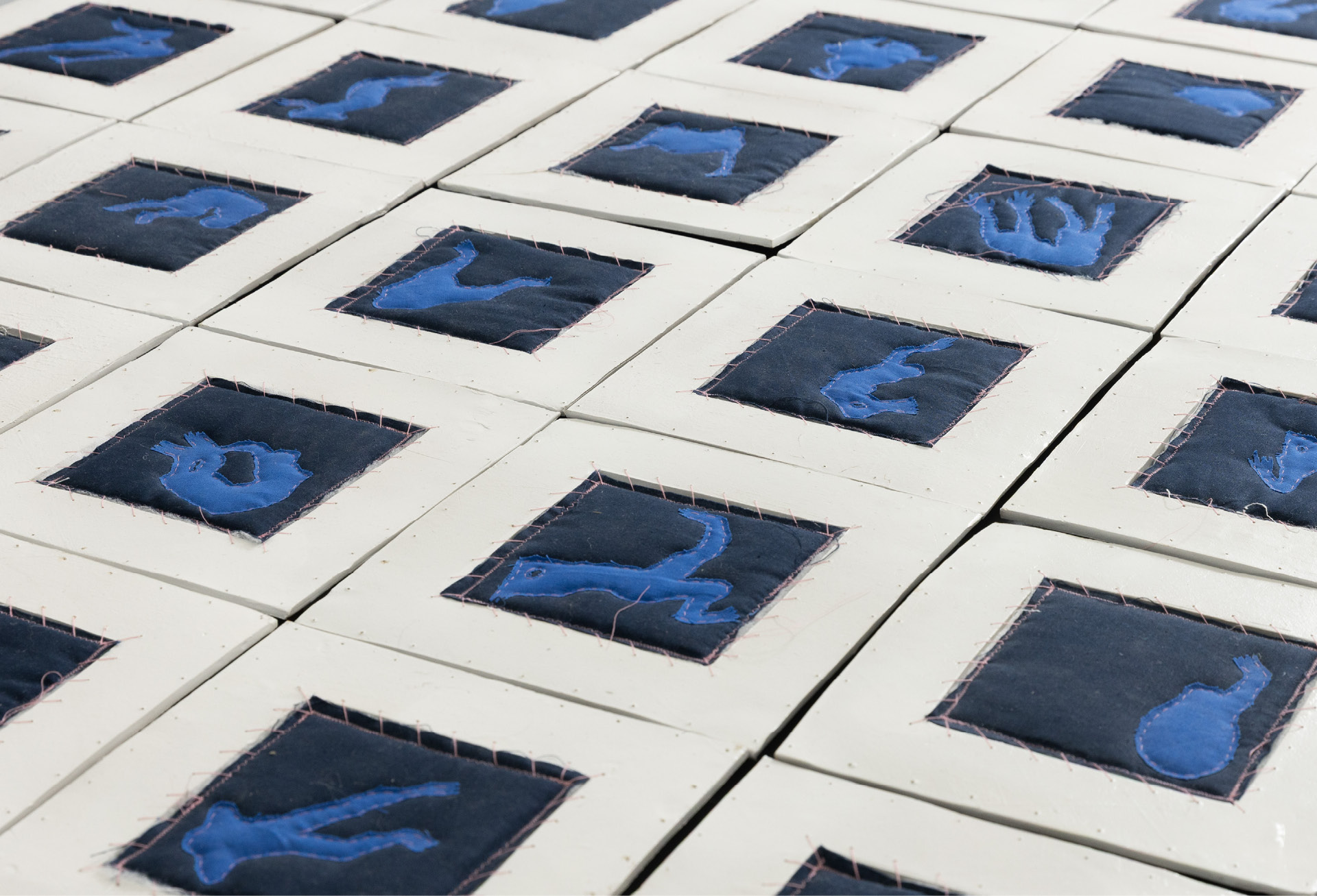 The sixty ceramic tiles laid out across the gallery floor
